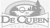 Logo of De Queen, featuring stylized text and a graphic of trees and water.